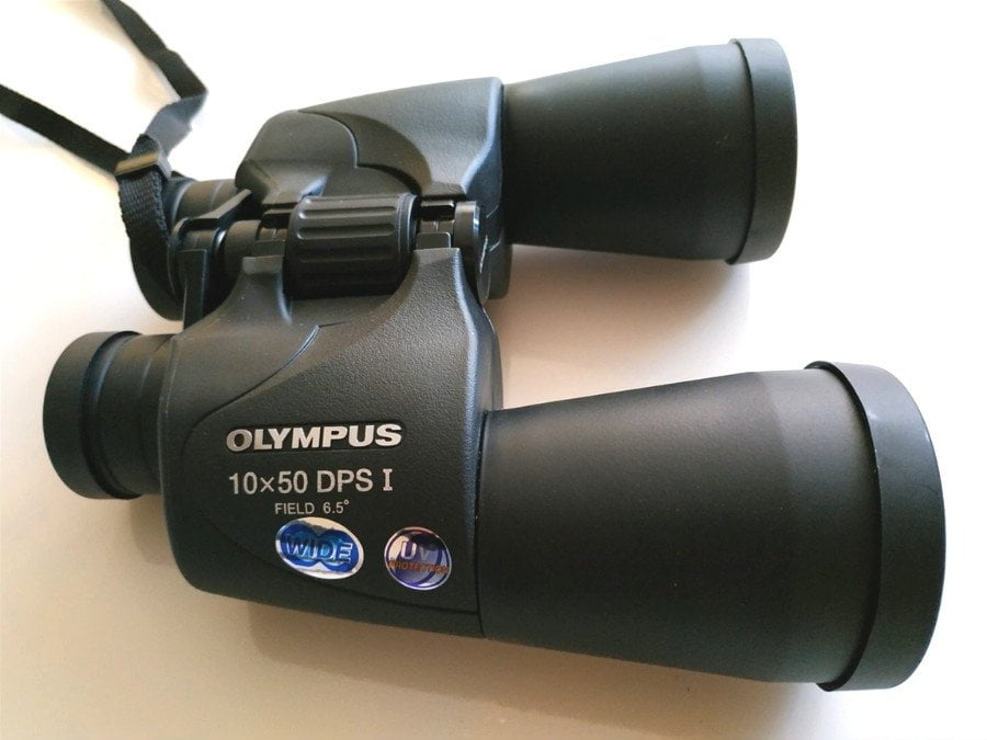 Foto sobre una mesa de los binoculares Olympus 10x50 DPS-I. Buenos prismáticos para ver planetas.