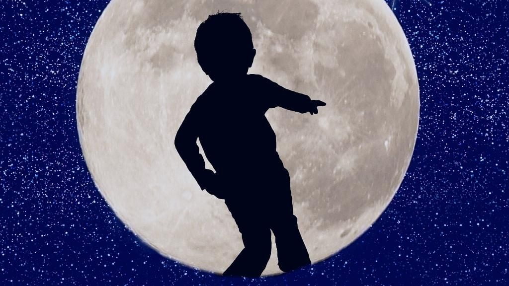 Imagen de un niño a contraluz con la Luna de fondo. En referencia a las fases de la luna para niños y niñas.