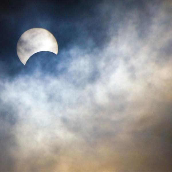 Foto de un instante de un eclipse de Sol visible entre las nubes.